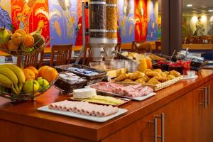 a buffet with food and fruit on a table at B&B HOTEL Amneville-les-Thermes in Amnéville