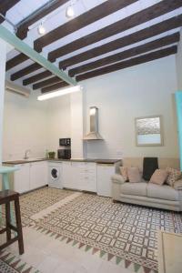 a living room with a couch and a kitchen at Vintage & Cosy Auditorium in Alicante