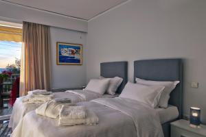 sypialnia z 2 łóżkami z białą pościelą i oknem w obiekcie Amazing Seafront Apartment Athens Riviera w Atenach