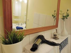 a bathroom with a blow dryer on a sink with a mirror at Ferienwohnung Graf Möwe in Ostseebad Karlshagen