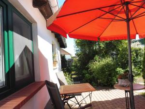 een oranje parasol en een tafel en stoelen op een patio bij Ferienwohnung Graf Möwe in Ostseebad Karlshagen