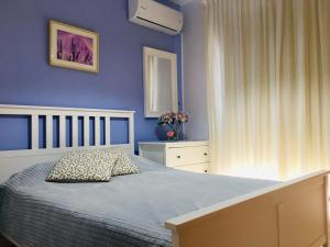 a blue bedroom with a bed and a window at Amorgos Gardens in Paphos City +33 photos