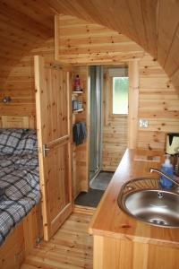 a bathroom in a log cabin with a sink and a bed at Glamping at Spire View Meadow in Lincoln