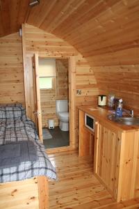 a bedroom in a log cabin with a sink and a toilet at Glamping at Spire View Meadow in Lincoln