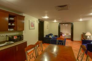eine Küche und ein Wohnzimmer mit einem Tisch und Stühlen in der Unterkunft Porto Marina Apartments By Amer-Group in El-Alamein