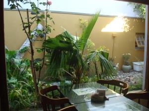 a table and chairs in a garden with plants at Hotel de Cine Las Golondrinas in Villa Gesell