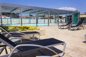a group of chairs sitting on a patio next to a pool at Hotel Boa - Vista in Porto +32 photos