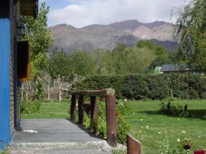 a wooden gate in a yard with mountains in the background at Cabañas Tierra del Sol Aldea de Montaña in Los Árboles