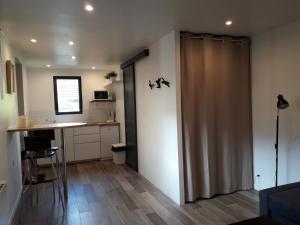 une chambre avec une porte coulissante dans une cuisine avec un comptoir dans l'établissement Studio avec jardin et stationnement gratuit à Rouen, à Rouen