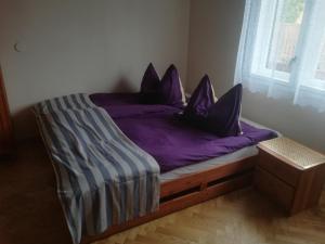 シオーフォクにあるLeander Houseの紫色のシーツと枕が備わるベッド1台