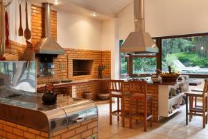 
a kitchen with a fire place, a stove, a table and chairs at Eco Resort Hotel Villa São Romão in Lumiar
