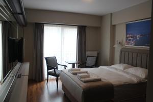 1 dormitorio con 1 cama, mesa y sillas en Armida City Hotel, en Canakkale