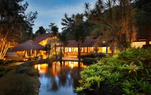 uma casa com um lago em frente em Eco Resort Hotel Villa São Romão em Lumiar