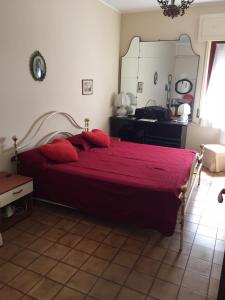 una camera da letto con un letto con lenzuola rosse e uno specchio di Relax e confort nella Perla dello Ionio a Soverato Marina