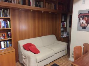 un soggiorno con divano bianco e cuscino rosso di Relax e confort nella Perla dello Ionio a Soverato Marina