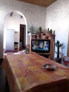 ein Wohnzimmer mit einem Tisch und einem TV in der Unterkunft dar stefano in Essaouira
