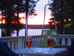 two glasses of wine sitting on a table on a balcony at Koskenselkä Camping in Puumala