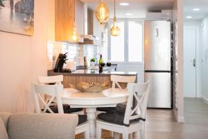 a kitchen with a table and chairs and a refrigerator at Al Andalus Playa Muchavista El Campello in El Campello