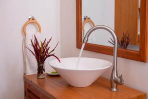 lavabo blanco en una encimera de madera en el baño en Mambo Hideaway, en Arusha