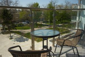 a glass table and two chairs on a balcony at SeaLine Apart-Hotel in Odesa