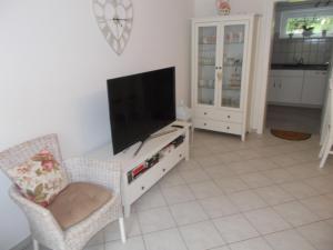 a living room with a flat screen tv and two chairs at Schlei-Rose in Kappeln