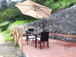 a table and chairs with an umbrella on a patio at Casa Lin in Celle Ligure