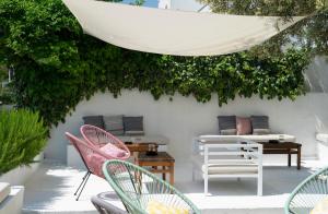 a patio with chairs and tables and a plant at Akti Hotel Kavala in Paleo Tsifliki