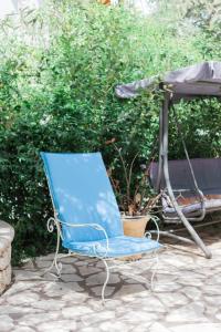 a blue chair sitting in front of a grill at Afroditi Pansion in Agios Nikitas