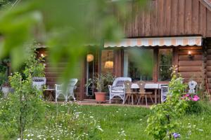 a house with a table and chairs on the porch at Bajtica Guesthouse in Bled