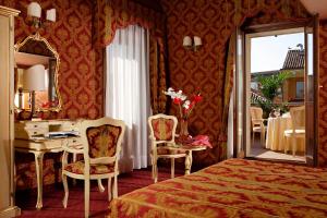 a bedroom with a bed and a desk and a mirror at Hotel Gorizia a La Valigia in Venice