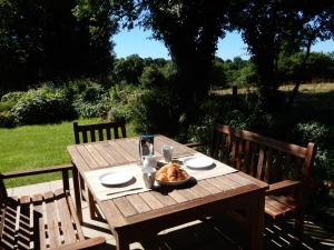 Marion's Cottage في Le Mesnil-Villeman: طاولة خشبية عليها صحن من الطعام