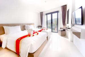 Ένα ή περισσότερα κρεβάτια σε δωμάτιο στο Phoenix Hotel Karon Beach