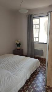 a bedroom with a white bed and a window at Magnifique appartement de style Catalan, au bord de la Plage du Grand Large pour location de vacances, de week-end, de nuité à Canet-en-Roussillon in Canet-en-Roussillon