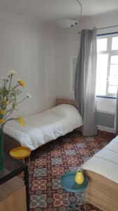 a room with two beds and a table and a window at Magnifique appartement de style Catalan, au bord de la Plage du Grand Large pour location de vacances, de week-end, de nuité à Canet-en-Roussillon in Canet-en-Roussillon