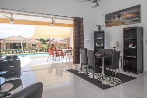 comedor con mesa, sillas y piscina en SOV 3 bedroom modern House, en Sosúa