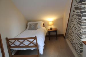 Dormitorio pequeño con cama blanca y lámpara en Marion's Cottage, en Le Mesnil-Villeman