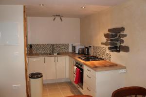 a small kitchen with a stove and a sink at Marion's Cottage in Le Mesnil-Villeman