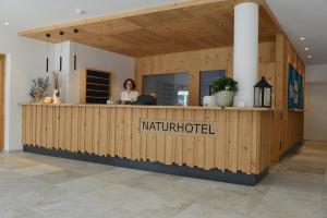 a woman is sitting at a counter in a building at Naturhotel Haller in Racines