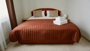 a bedroom with a bed with a red comforter at Zhuliany City Hotel in Kyiv