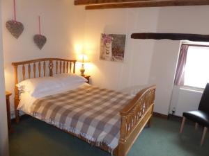 a bedroom with a bed and a window with hearts on the wall at SWALLOWS RETURN in Hartington