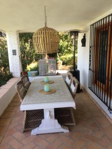 a patio with a table and chairs and a chandelier at villaquinta in La Herradura