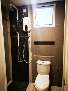 a bathroom with a shower and a toilet and a window at Kampar Champs Elysees, King Bed Studio unit 12A21 in Kampar