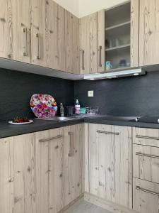 a kitchen with wooden cabinets and black counter tops at helios apartmenthouse in Olympic Beach +18 photos