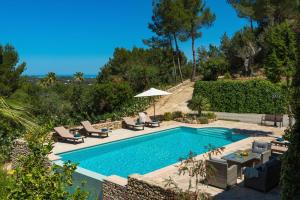 una piscina con sillas y un patio con sombrilla en Finca Niko en Santa Eulalia del Río