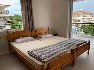 a bedroom with a bed and a large window at helios apartmenthouse in Olympic Beach