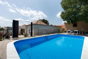 a swimming pool in front of a house at Drnis Dream House in Drniš