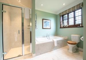 
a bathroom with a tub, toilet, sink and shower at Hever Castle Luxury Bed and Breakfast in Edenbridge
