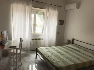 a bedroom with a bed and a desk and a window at Allegra B&B in Terracina