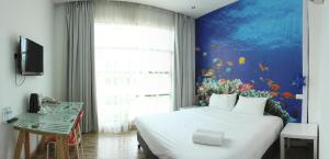 1 dormitorio con 1 cama grande con una pared de pescado en V Garden Hotel en Kuala Lumpur