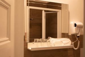 un baño con lavabo y espejo en Sogno di un'epoca, en Roma 39 fotos más